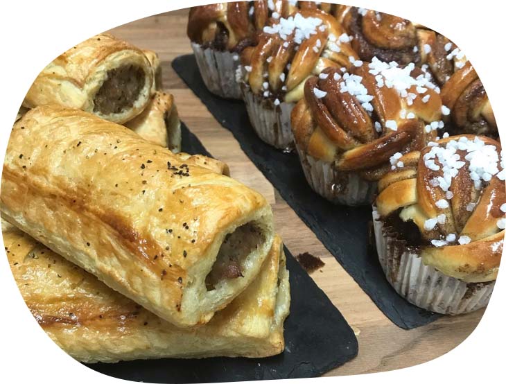 A close-up image of sausage rolls and muffins produced by Wild Heart Café.